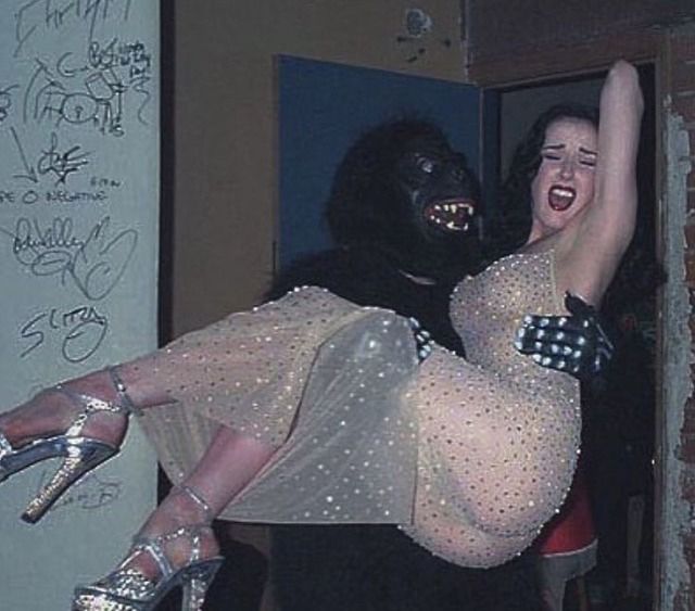 Dita Von Teese in the arms of a person in a gorilla suit
