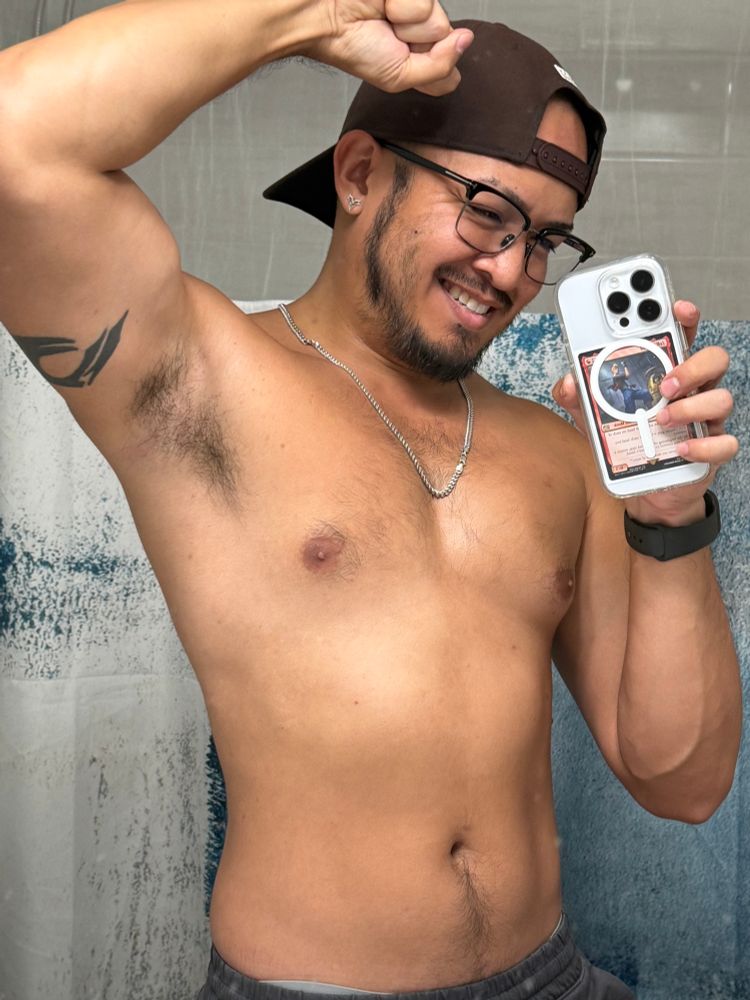 Shirtless mirror selfie with left bicep flexed