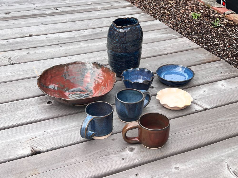 Various blue, red and cream colored ceramic vessels.
