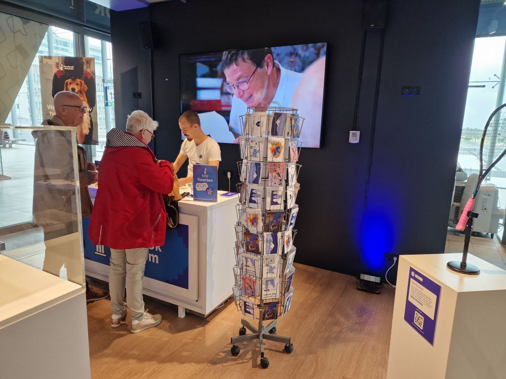 People at the desk in front of a video screen at the Facebook Museum 