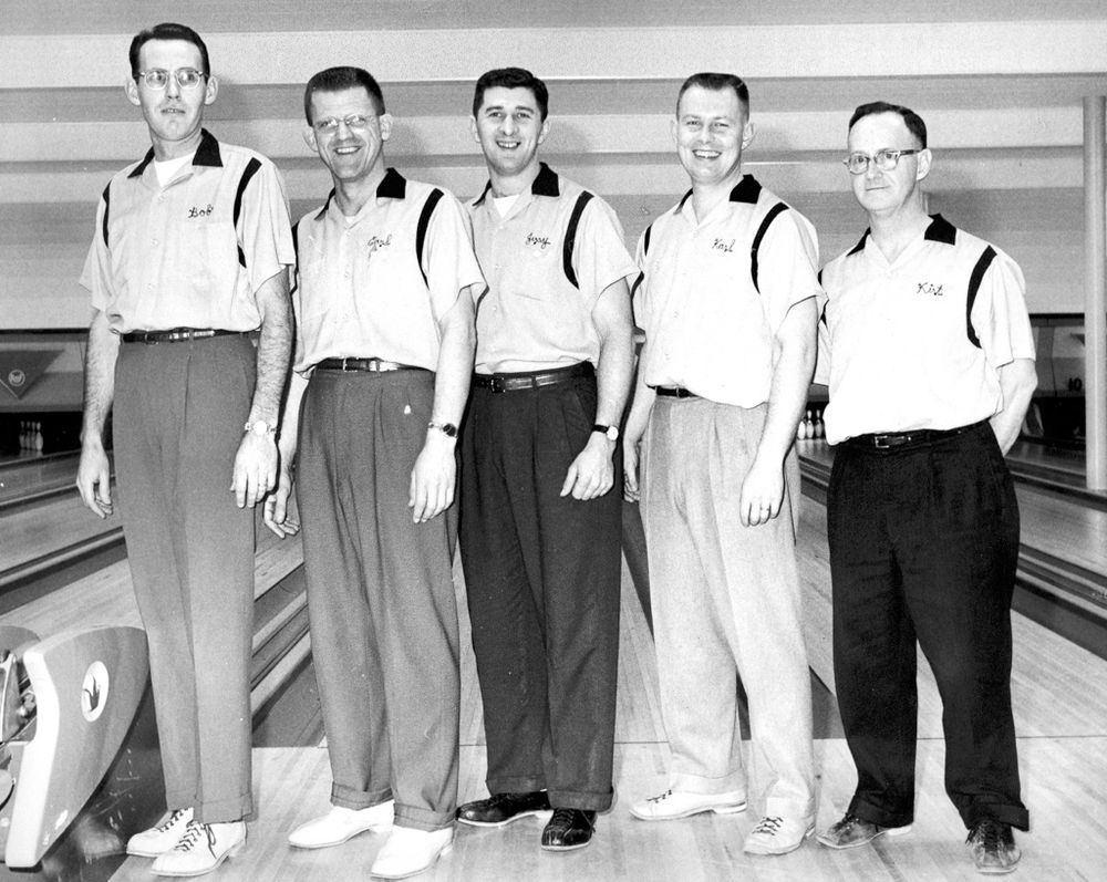 A bowling team of five men in a bowling alley wearing bowling shirts. Akron, OH late 50s - early 60s.