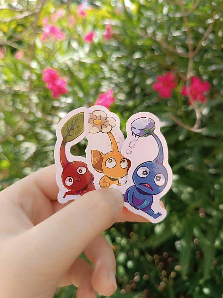 A photo of 3 pikmin stickers (red pikmin, yellow pikmin, blue pikmin) designed by me. 