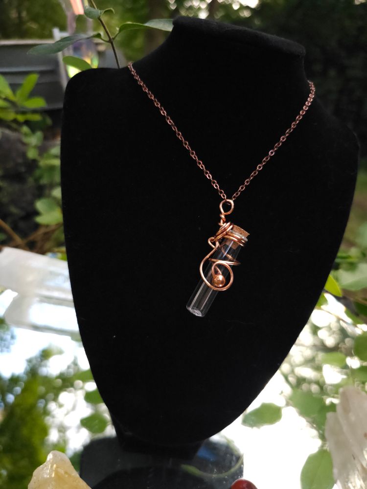 Tiny empty glass bottle wrapped in copper wire and made into a pendant 