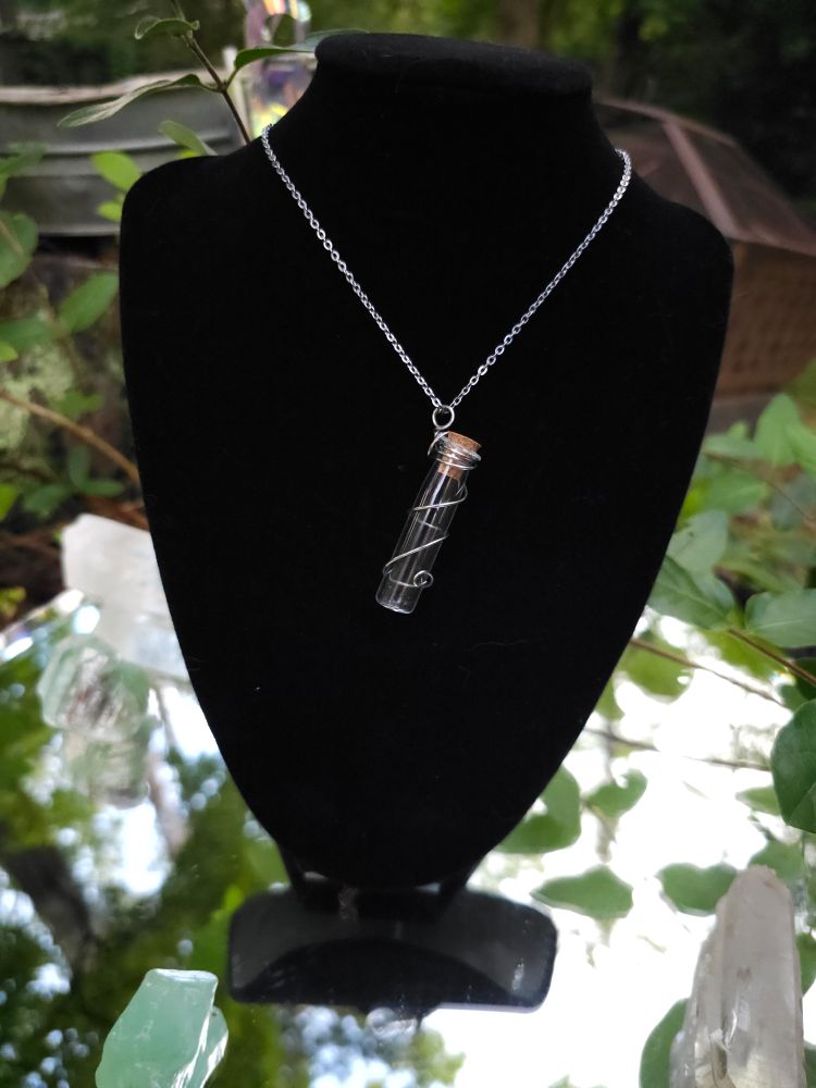 Long empty mini bottle wire wrapped into a pendant. 