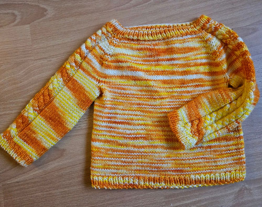 A jumper in a funky white orange and yellow patern