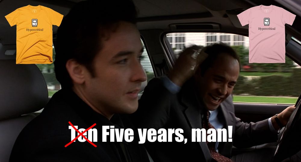 The scene in Grosse Pointe Blank where John Cusack and Jeremy Piven are in a car, and Piven can’t believe Cusack has been gone for “Ten years, man!” In the subtitle text, the word “Ten” is crossed out with a red “X” and “Five” is written in its place. A gold Hypercritical t-shirt and a pink Hypercritical t-shirt appear in the upper left and right corners of the frame.
