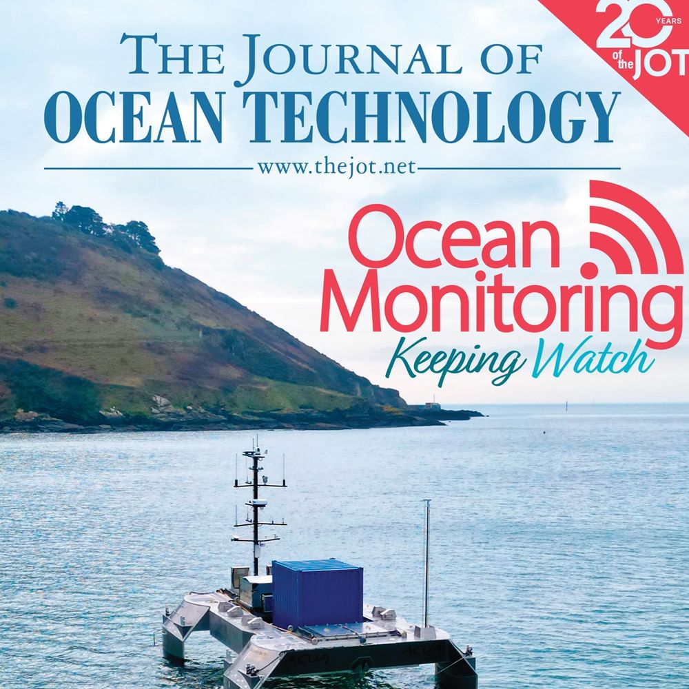 Unmanned surface vessel in the ocean near shore with a rocky-grassy cliff in the background.