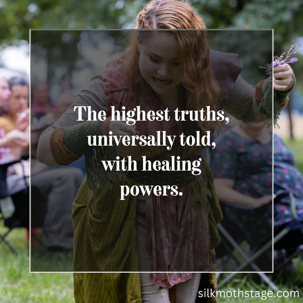Actor Amber James, portraying Sambai the monster eater, drops flowers in green grass as she casts a spell. Her costume is green and pink. Behind her, in soft focus, some audience members watch.