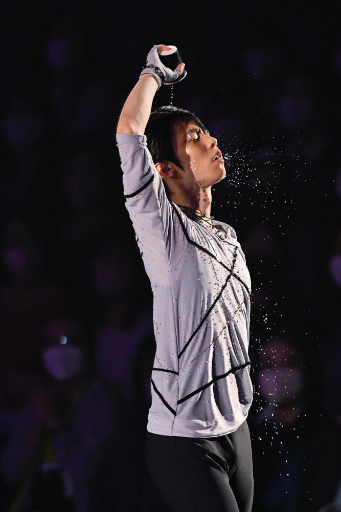 Yuzuru Hanyu pouring water on himself with a paper cup during his real face program the picture show him from his upper thighs