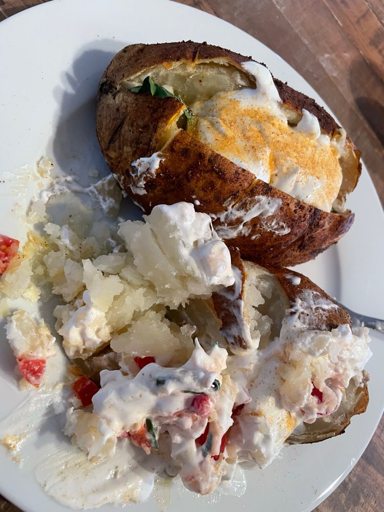 Baked potato with seasoned skin, butter, sour cream, tomato’s, onions, spinach 