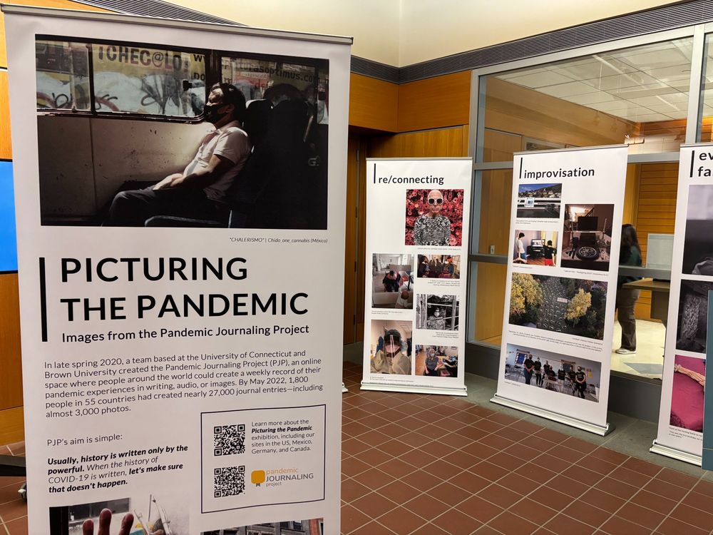 Image shows exhibit banners for the Pandemic Journaling project exhibition, Picturing the Pandemic, in the entrance to the University of Connecticut's Babbidge Library. Exhibition website is at https://picturingthepandemic.org/.