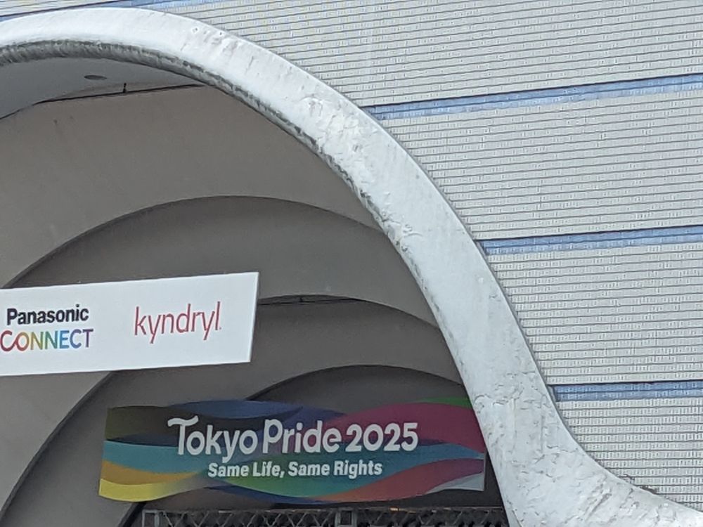 Tokyo Pride 2025のロゴと「Same Life, Same Rights」のスローガンが描かれた看板。上部にPanasonic CONNECTとkyndrylのロゴも表示されている。
