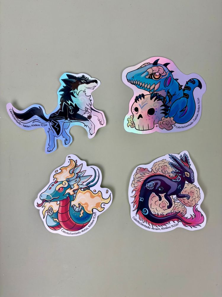 4 stickers of some Kódem characters, Yakker a Mexican wolf, Zaykan a blue iguana over a sugar calaverita. A chivo Kettz and a chivo axolotl over cempasuchil flowers 