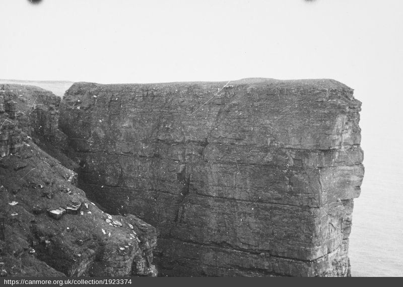 This black and white image shows the flat platform and precipitous cliffs around the promontory fort of Brae Brough on Hoy in Orkney.