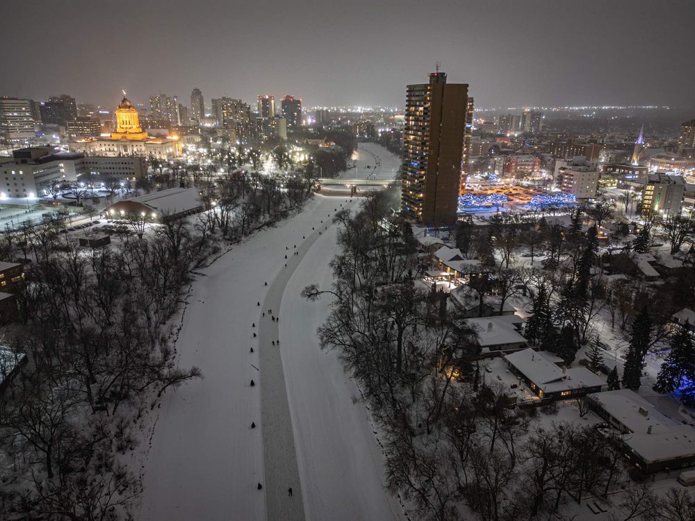 People skating on the frozen Assiniboine River that runs through downtown Winnipeg.  