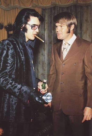 elvis, wearing sunglasses at night, black leather gloves, and a high-collared velvet coat, smoking a cigar while holding a beer and a flashlight, as Glen Campbell looks stunned