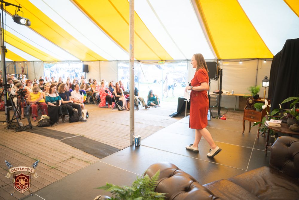 Speaker on podium in festival tent, taken from back stage