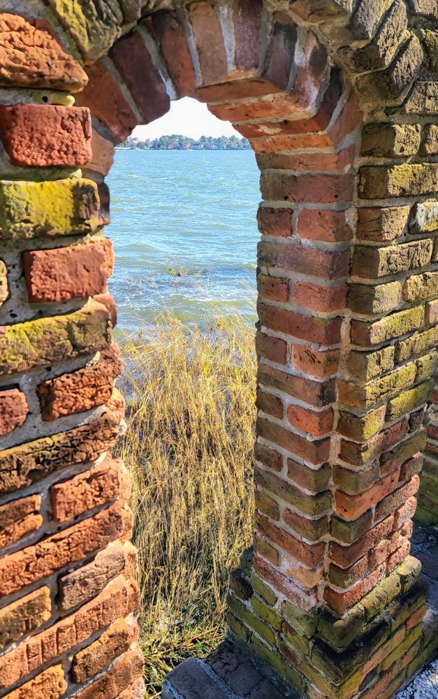 Brick arch in foreground looking out onto marshy shore and Lafayette River.
