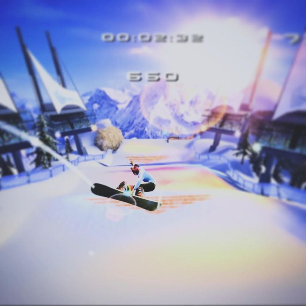 A girl performs an epic trick on her snowboard as she dashes down a mountain in the bright winter sunlight.
