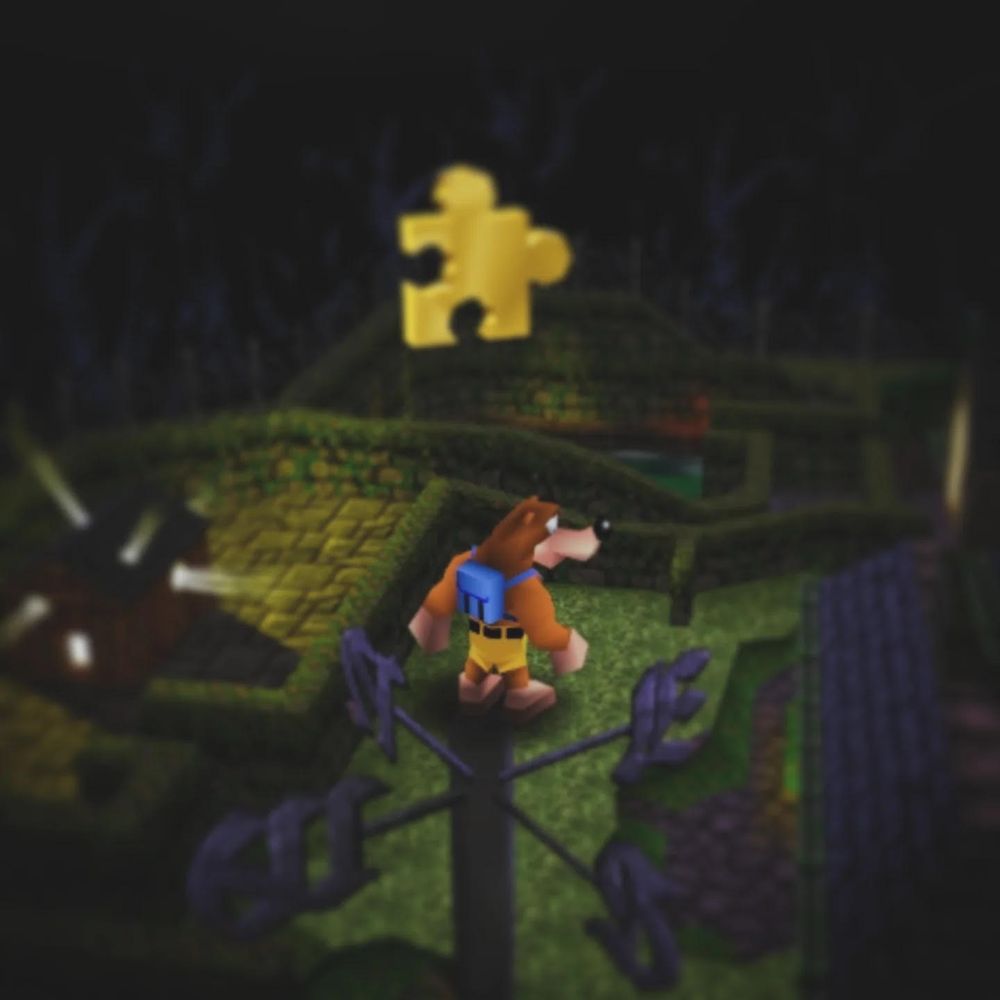 Banjo, a bear donning a blue backpack and yellow shirts, stands atop a tall post near a haunted mansion. Above him twirls a magical gold puzzle piece called a "Jiggy".