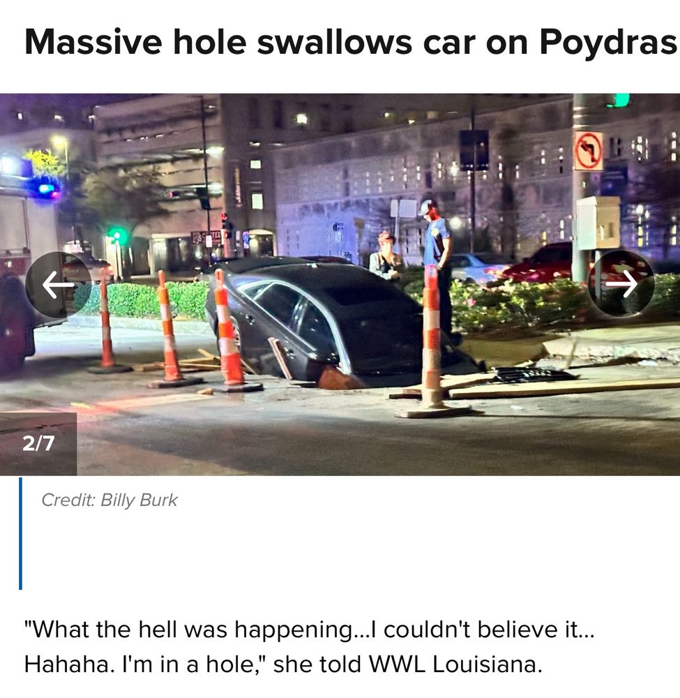 A photo of a grey sedan which has driven into a large hole. The front end is totally in the hole! There are some cones. The title says “Massive hole swallows car on Poydras” and the caption reads as folllows: “What the hell was happening… I couldn’t believe it… Hahaha. I’m in a hole,” she told WWL Louisiana.