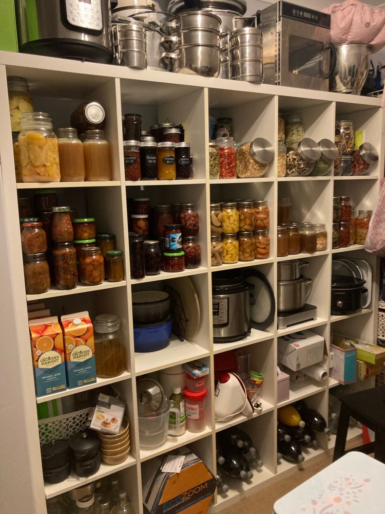 A 5 x 5 IKEA shelving unit stuffed full on of coloured food in jars 