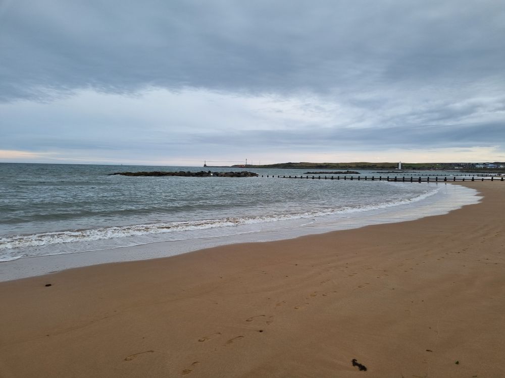 the Aberdeen city beach, looking south, with Girdle Ness Lighthouse in the distance and the sky looking very dramatic