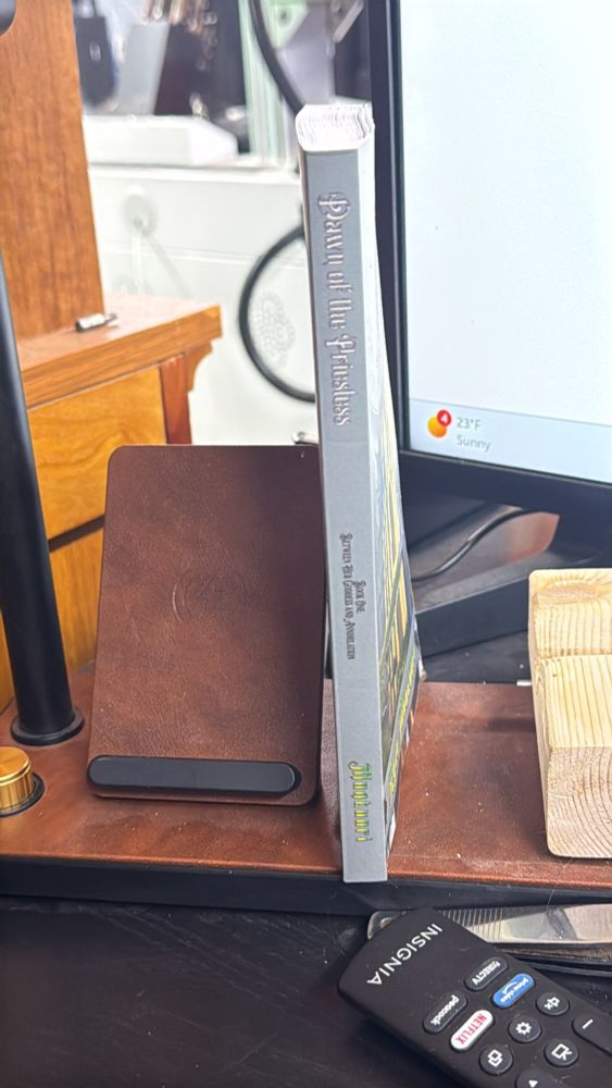 The spine of the book next to a mobile phone charging stand.