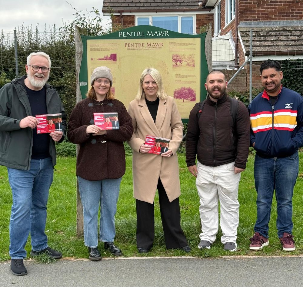 Alt text:
Five people standing in front of a Pentre Mawr sign, holding leaflets and smiling at the camera.

Testun amgen: 
Pump o bobl yn sefyll o flaen arwydd Pentre Mawr, yn dal taflenni ac yn gwenu ar y camera.