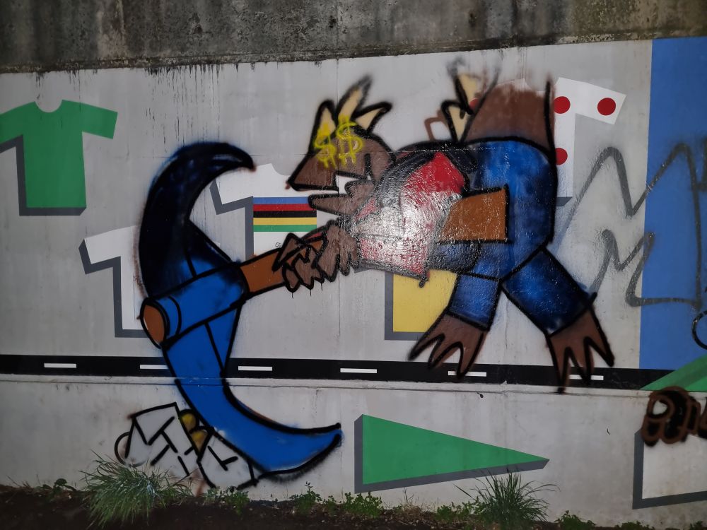 A wall painted with the squarish lizard prospector fiding gold hidden in the rocks