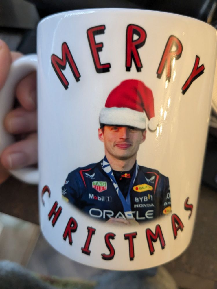 Max Verstappen wearing a Santa hat on a mug that says "Merry Christmas" 