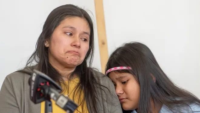 A Native American mother with her child in deep distress giving a press conference