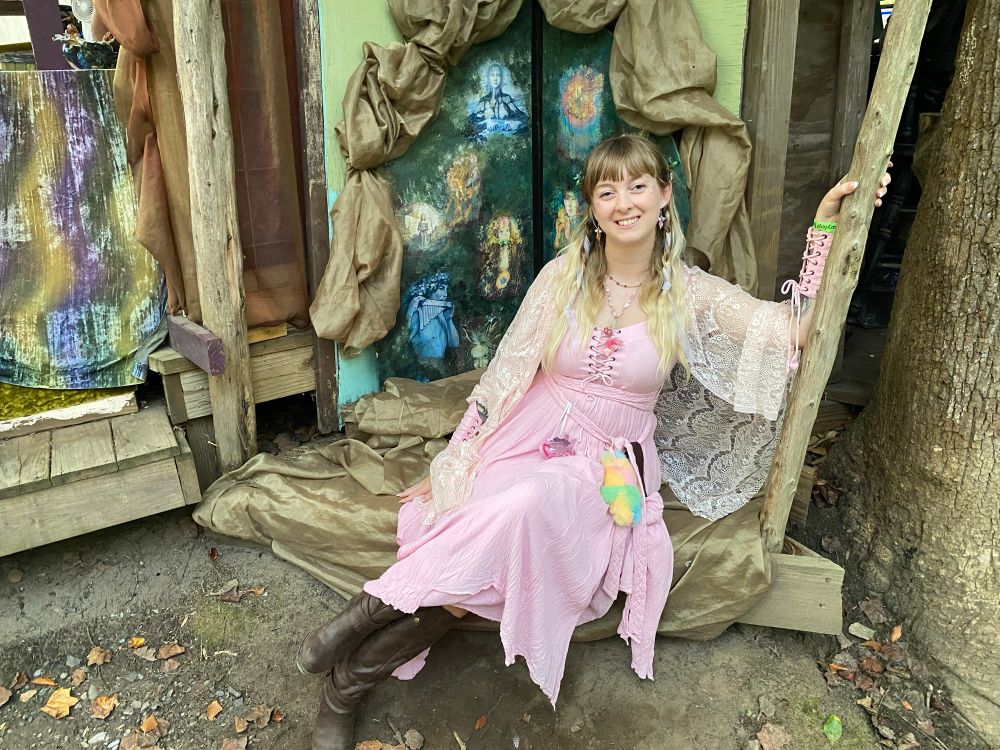picture of me from renn fest last weekend in pink fantasy garb with a pastel tie dye labubu on my belt