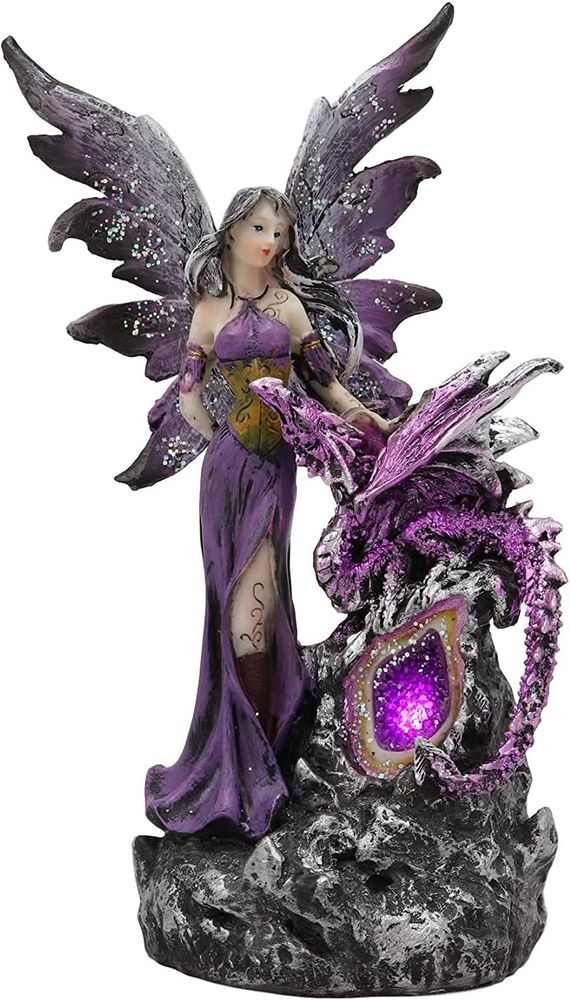 one of those statues with a fairy woman and a dragon. it's purple and black and glittery with some kind of gemstone. very kitsch collectible 