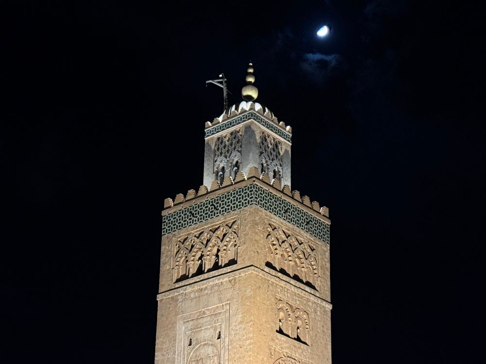 Marrakech’s Koutouba mosque at night under a half moon 