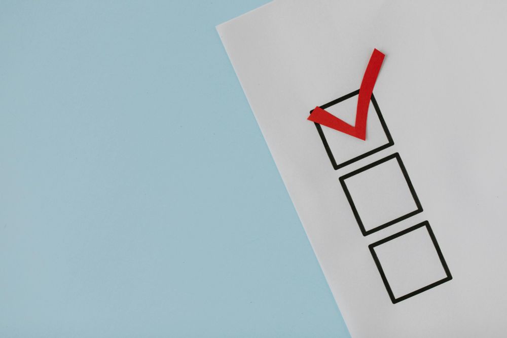 Close-up of a red check mark on a crisp white paper with black boxes, symbolizing completion.