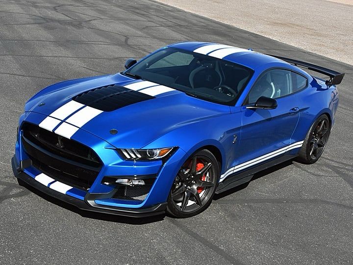 A 2020 ford mustang Shelby gt500 painted blue with 2 white stripes running down the middle of it 