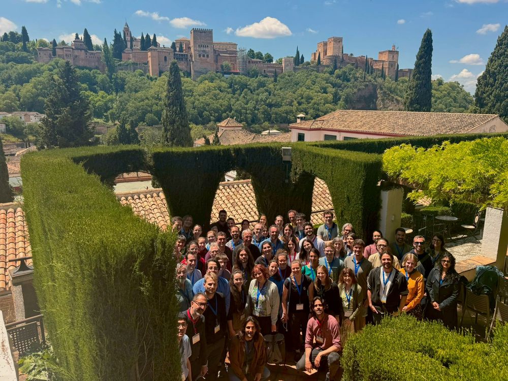 A photo of a group of people with the Alhambra in the back