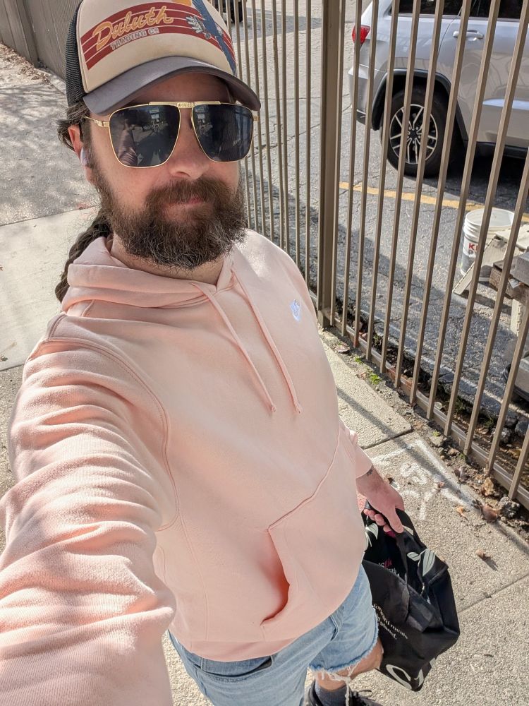 Me in a Duluth trading hat, Guess aviators, a pink Nike sweater, and light wash cut off jeans