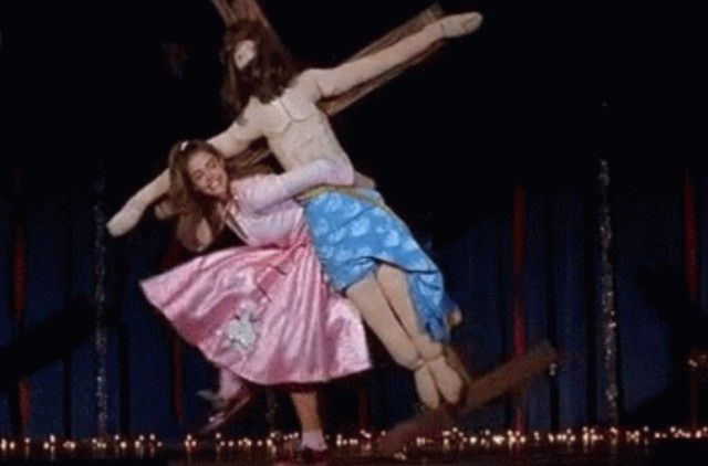Still from Drop Dead Gorgeous of Becky carrying Jesus on the cross during her musical number. 