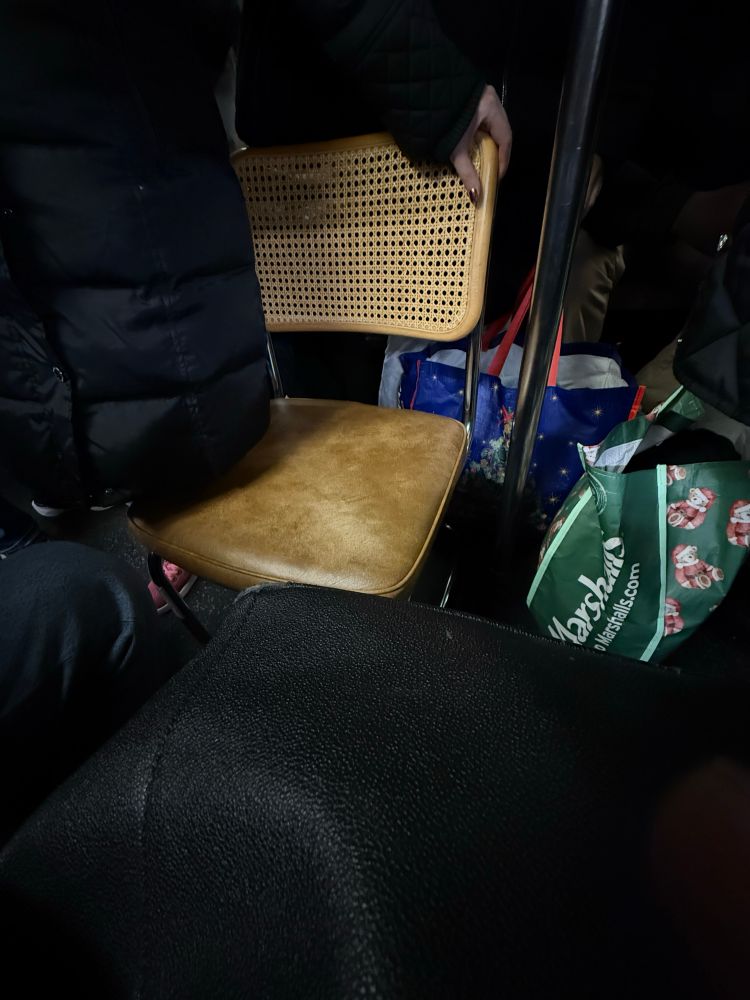 A chair on a packed subway train.