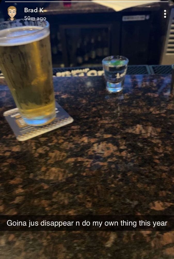 A Snapchat post by Brad K showing a photo of a beer and a shot glass on a bar. Caption reads "Goina jus disappear n do my own thing this year"