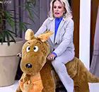 a woman is riding on the back of a stuffed animal kangaroo .