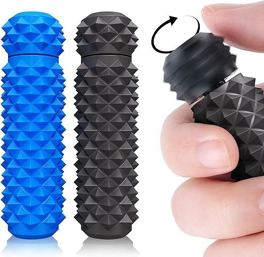 Two blue and black fidget toys consisting of cylinders with a pattern of spiky pyramid shaped points all over and a spinny top that a hand off to the right side can be seen twirling.