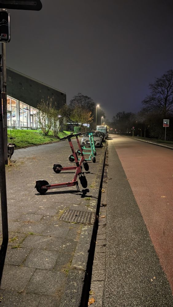 5 eScooter auf dem Gehweg an der Bismarckallee Ecke Platz der Weißen Rose an einer Fahrradstraße, neben einer Realschule. Sie wurden Sauber am Rand in einer Reihe hingestellt. Ein Werk der Ordnung, Schönheit und des Friedens ;-)