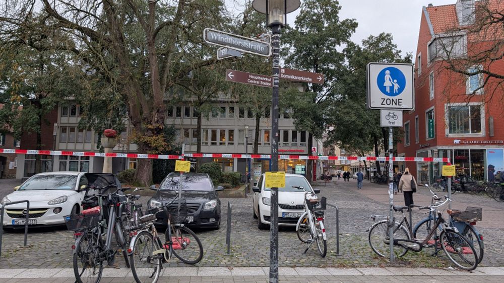 Situation am Harsewinkelplatz: Flatterband über den Fahrradbügeln mit der Ankündigung, dass für "Reinigungsarbeiten" alle Fahrräder zu einem Stichtag entfernt werden müssen, ansonsten würden die Räder eingesammelt und umgesetzt (unter gewaltsamer Öffnung der Schlösser, wenn die Räder angeschlossen sind > Sachbeschädigung), für die PKW dahinter interessiert sich die Stadt nur, wenn die Fläche für Veranstaltungen genutzt wird. Sonst werden PKW, die in der Fußgängerzone geparkt werden geduldet. In Münster ist jede freie Fläche > 10 m² potentieller Parkplatz.