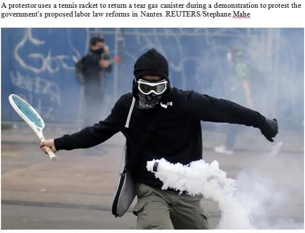 Picture: A protestor, dressed in black Hoody with ski-googles and face-mask, uses a tennis racket to return a tear gas canister during a demonstration to protest the government's proposed labor law reforms in Nantes. REUTERS/Stephane Mahe