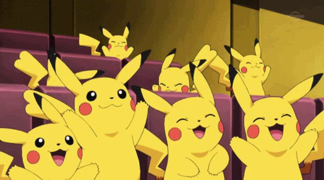 a bunch of pikachu are sitting in purple seats with their arms in the air