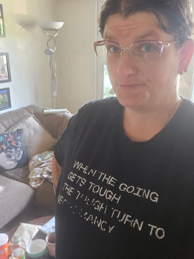 The author gives the camera a determined but trepidatious look, wearing a laundry-faded shirt that reads "When the going gets tough, the tough turn to necromancy"