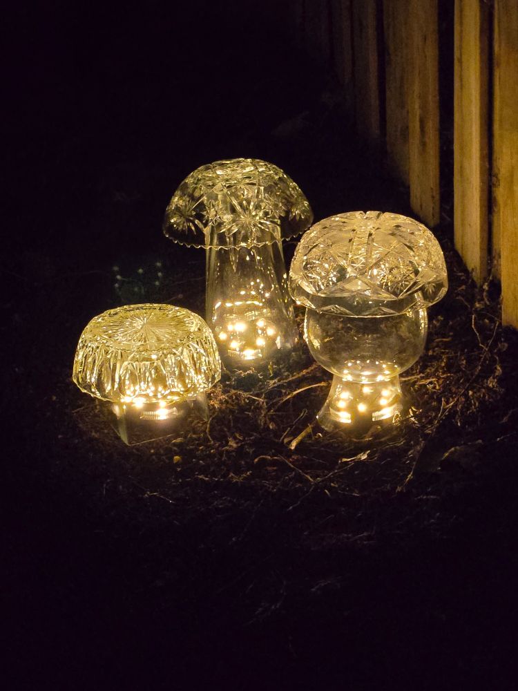 A trio of amazing glass mushrooms light up the author's garden at night